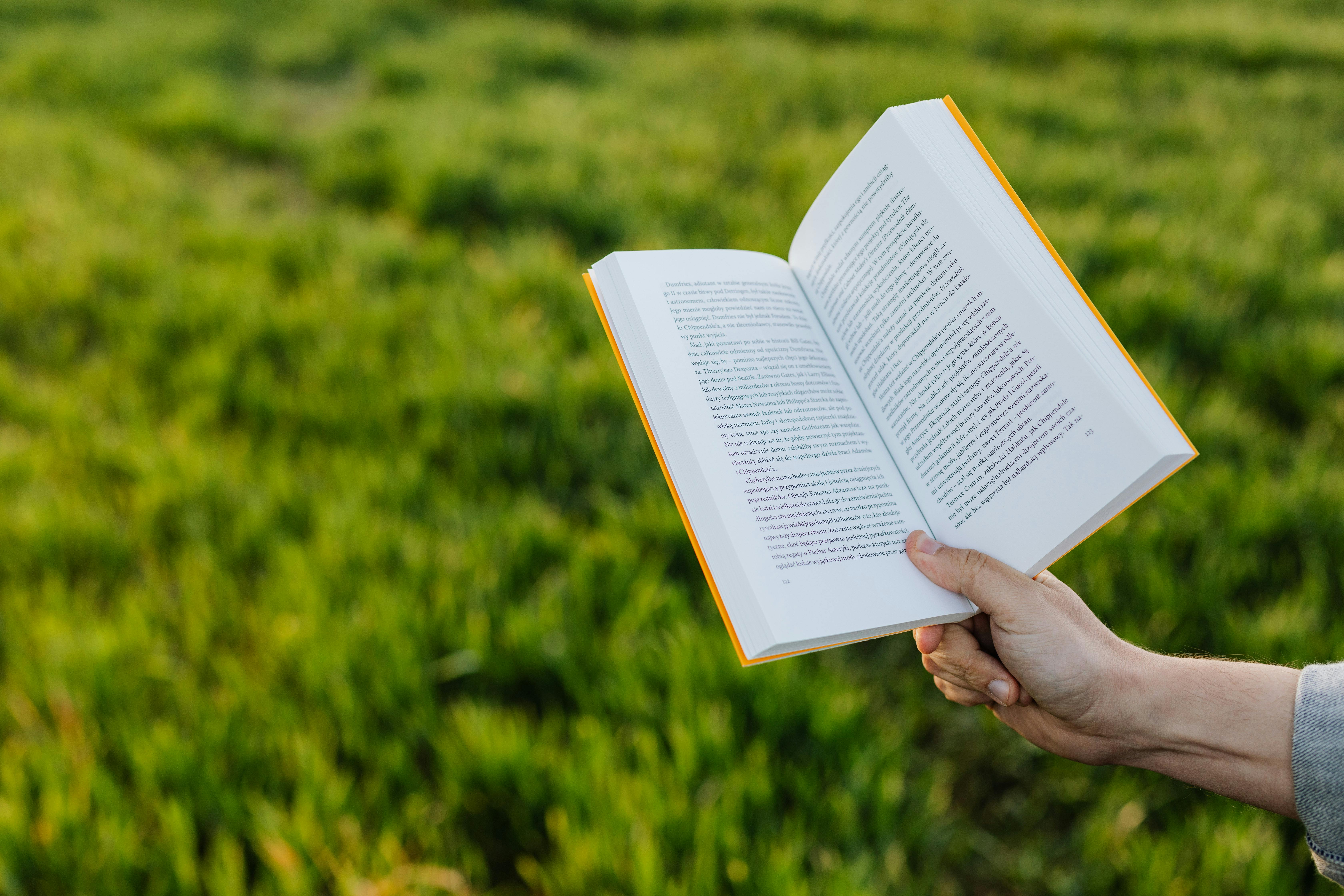 Book held in outstreched arm